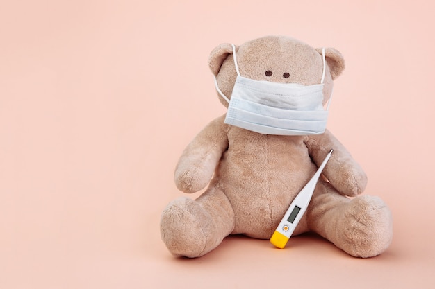 Stuffed Bear animal presented as a pediatrician with doctor's tools isolated on pink.