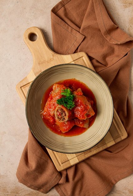 Stuffed cabbage rolls with minced meat in tomato sauce on a beige background top view no people selective focus