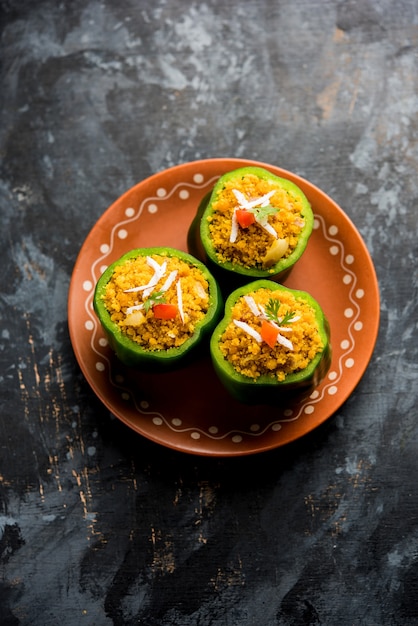 Stuffed  capsicum or bharwa shimla mirchi is a popular Indian main course recipe. Served in a plate over moody background. Selective focus