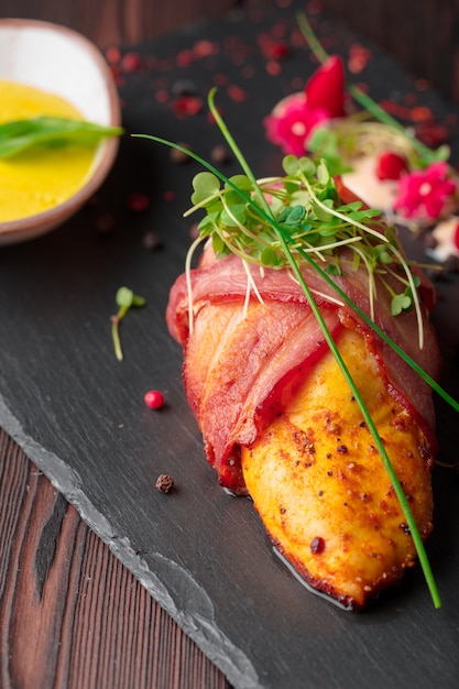 Stuffed chicken breast wrapped in bacon on a plate close-up