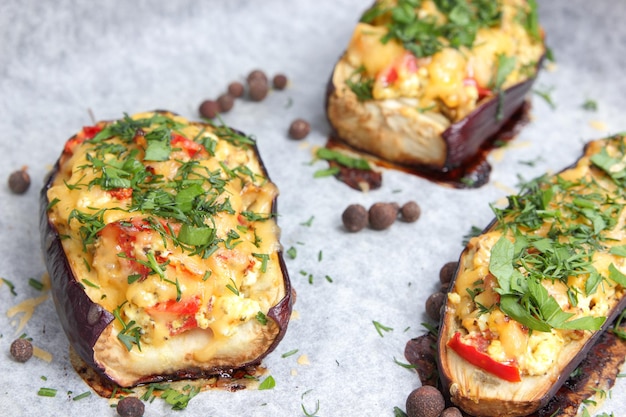 Stuffed eggplant from the oven. Eggplant baked in the oven on parchment with cheese, tomato and herbs