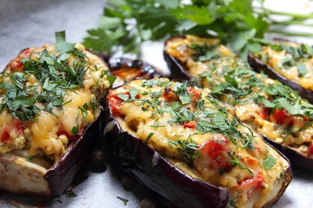 Stuffed eggplant from the oven. Eggplant baked in the oven on parchment with cheese, tomato and herbs