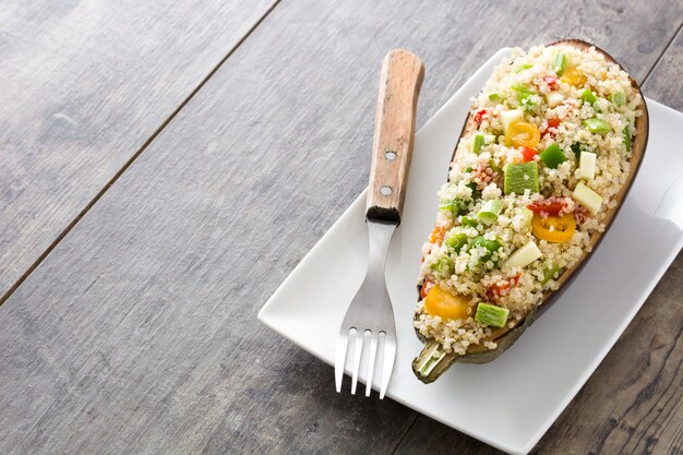 Stuffed eggplant with quinoa and vegetables on wooden