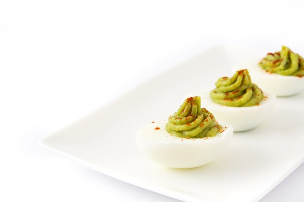 Stuffed eggs with guacamole isolated on white