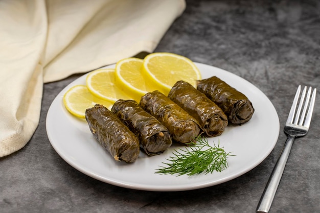Stuffed grape leaves with olive oil on a dark background Traditional Turkish cuisine delicacies Delicious dolma yaprak sarma Horizontal view Close up