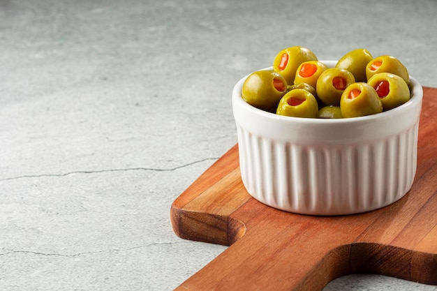 Фаршированные зеленые оливки в миске.
