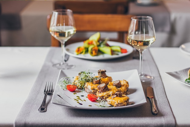 Stuffed mushrooms filled with cheese, mushroom stems, fresh cherry tomatoes and microgreen