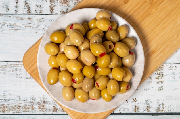Stuffed olives Green olives stuffed with dry peppers on a wooden background Mediterranean flavors Top view