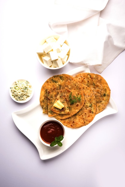 녹는 버터와 속을 채운 Paneer Paratha, 신선한 코티지 치즈 큐브 및 토마토 케첩과 함께 제공됩니다. 선택적 초점