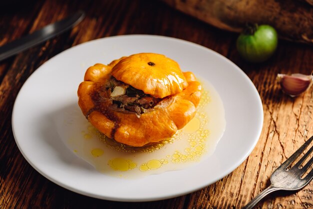 Stuffed pattypan squash on white plate over wooden rustic surface