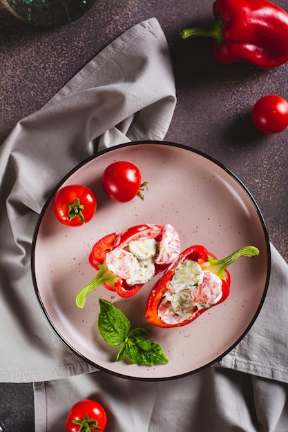 Stuffed peppers with fresh vegetable salad with yogurt on a plate top and vertical view