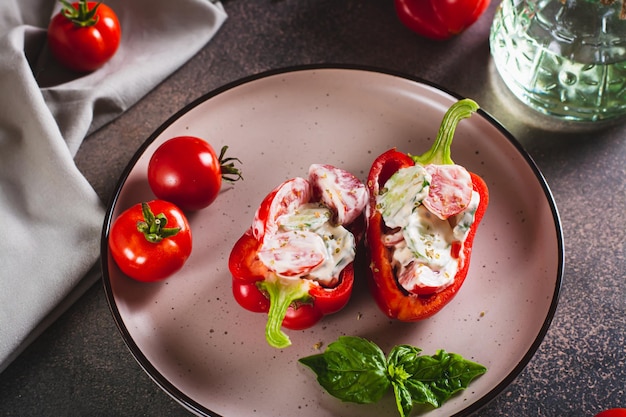 Stuffed peppers with fresh vegetable salad with yogurt on a plate