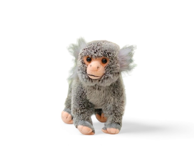 A stuffed spider monkey animal with a feathered head and tail isolated on white