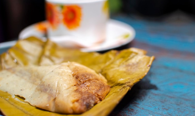 Stuffed tamale served on wooden table stuffed tamale on banana leaf served on wooden table