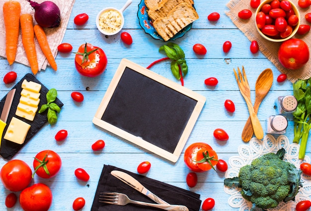 Foto pomodori ripieni con formaggio e verdure diverse, su un tavolo di legno,