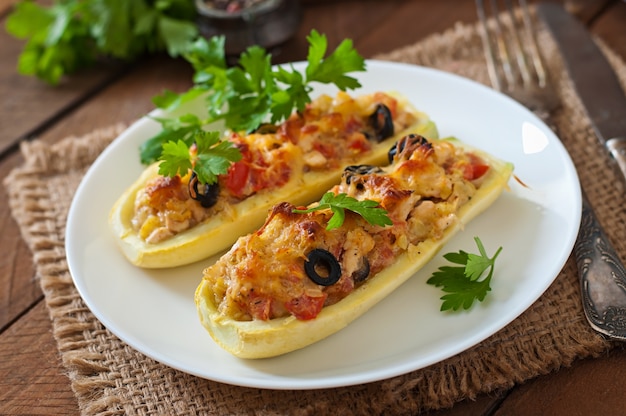 Stuffed zucchini with chicken, tomatoes and olives with cheese crust