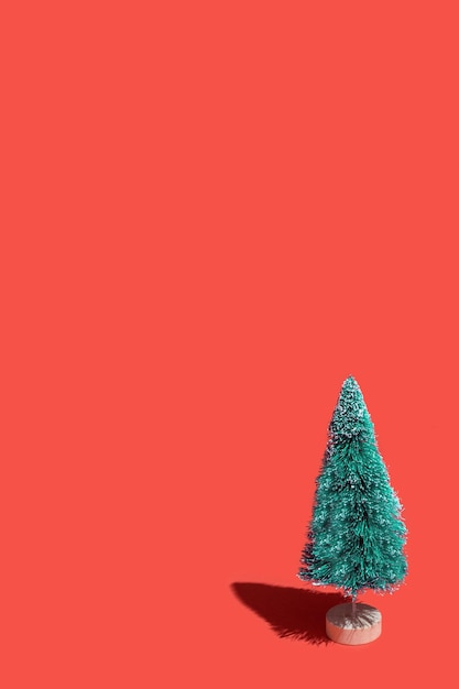 Stuk speelgoed kerstboom op een rode achtergrond grappige groene kunstmatige kerstboom