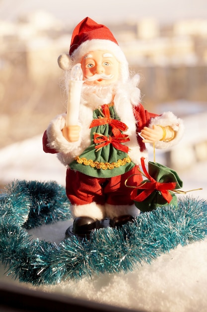 Stuk speelgoed Kerstman in rode kleren met een kaars in een hand