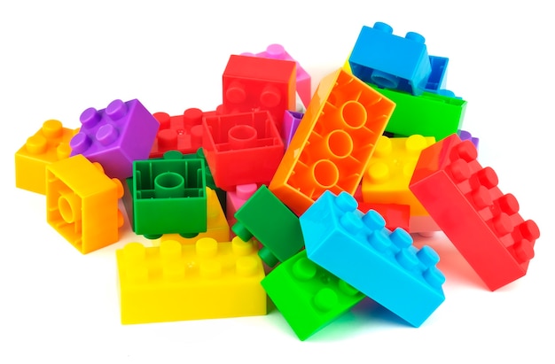Stuk speelgoed kleurrijke plastic blokken die op witte achtergrond worden geïsoleerd