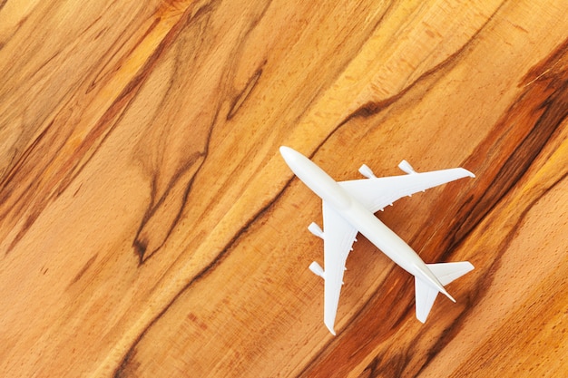 Stuk speelgoed van passagiersvliegtuig op houten achtergrond