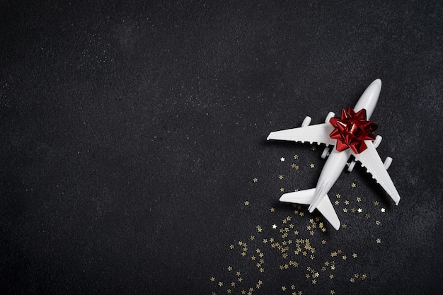 Stuk speelgoed wit vliegtuig met gouden sterren. kerstconcept van reizen en bezorgen per vliegtuig, nieuwjaar