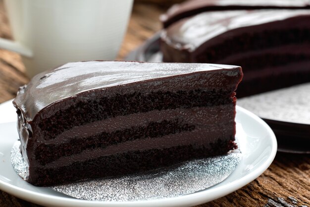 Stuk van de cake van de dessertchocolade op witte plaat.