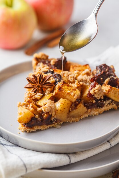 Foto stuk van veganistappeltaart met kaneel en stroop, witte achtergrond. veganistisch eten concept.