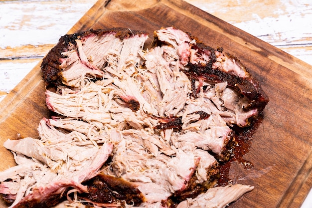 Stuk varkensvlees ingewreven met een rub en gekookt op de barbecue om een pulled pork te maken.
