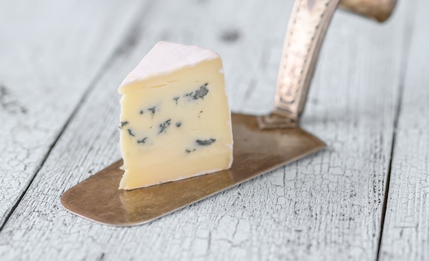 Stukje blauwe kaas onder een korst van witte schimmel