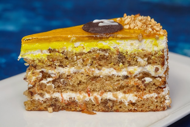 Stukje carrot cake met suikerglazuur en walnoot op plaat