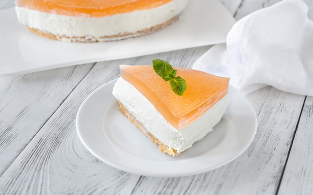 Stukje grapefruit cheesecake op witte achtergrond