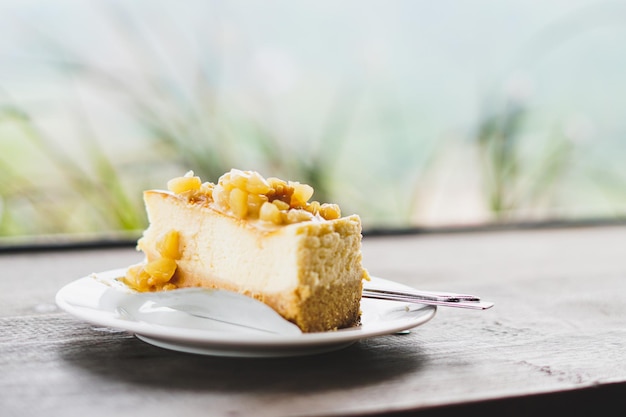 Foto stukje macadamia cake in plaat op houten tafel