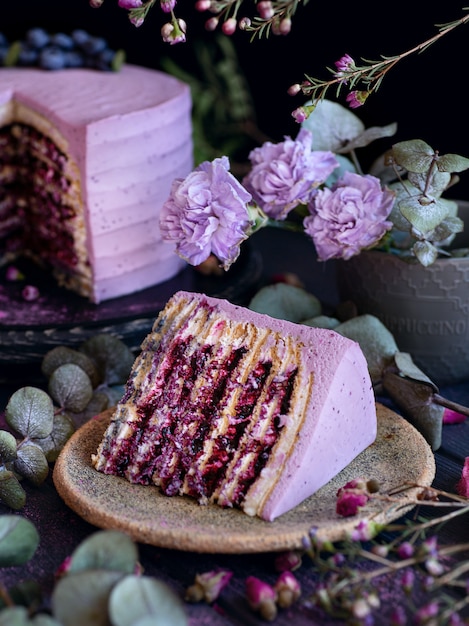 Stukje rozen fruit cake op de plaat met bramen en violet bloemen