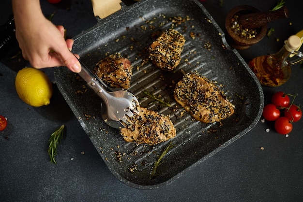 Stukjes biologisch tonijnfilet bedekt met sesamzaadje gebakken op een hete grillpan