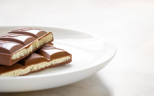 Stukjes chocolade in witte plaat op tafel