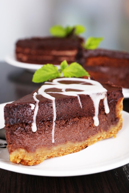 Stukjes chocoladetaart op borden op houten tafel op natuurlijke achtergrond