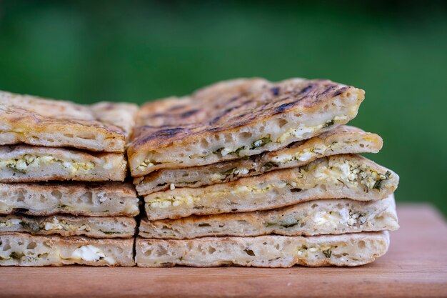 Stukjes gebakken deegtortilla met kwark en kruiden op een houten tafel, close-up, traditioneel Turks gerecht