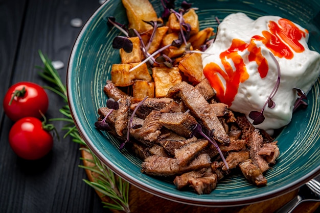 Stukjes gebakken vlees met roomsaus en gebakken aubergine