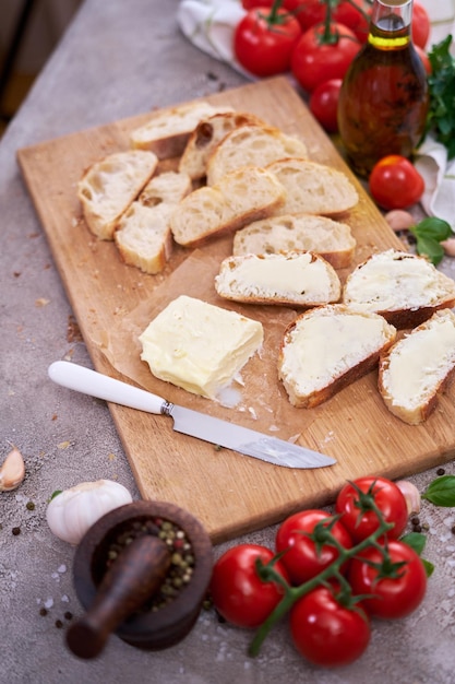 Stukjes gesneden stokbrood met smeerboter op houten plank