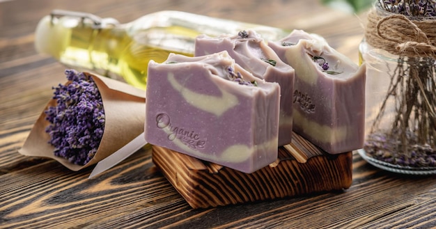 Stukjes traditionele Franse zeep op een houten zeepbak en een boeket lavendel Natuurlijke handgemaakte Marseille zeep met lavendel geur