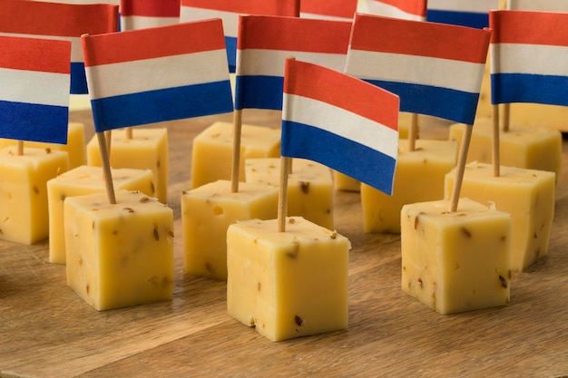 Stukjes traditionele Nederlandse komijnkaas met een rood-wit-blauwe vlag als tussendoortje close-up