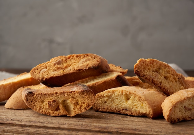 Stukken gebakken Italiaanse koekjes van Kerstmisbiscotti op een bruine houten raad