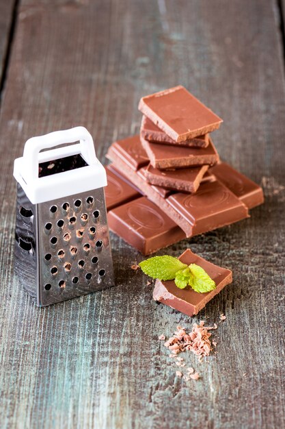 Stukken van chocolade op een houten achtergrond