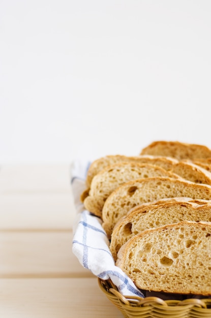 Stukken vers eigengemaakt brood op een witte handdoek in mand