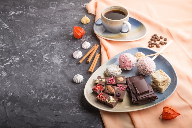 Stukken zelfgemaakte chocolade met kokossuikergoed en een kop koffie. zijaanzicht