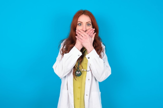 Фото Ошеломленная женщина-врач закрывает рот обеими руками, боясь чего-то удивительного