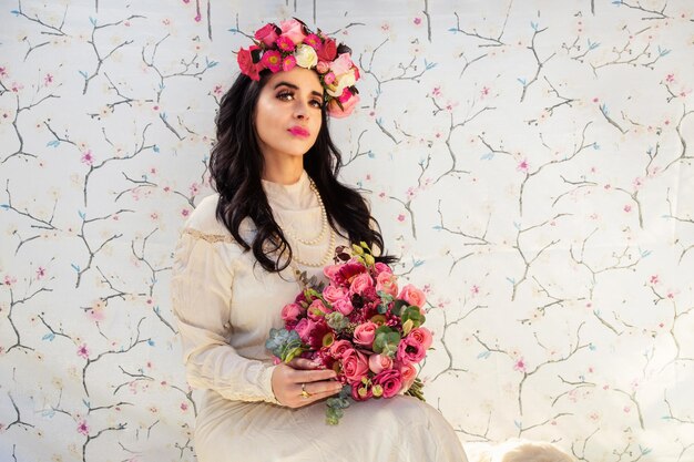 Stunning girl with big bouquet flowers of roses