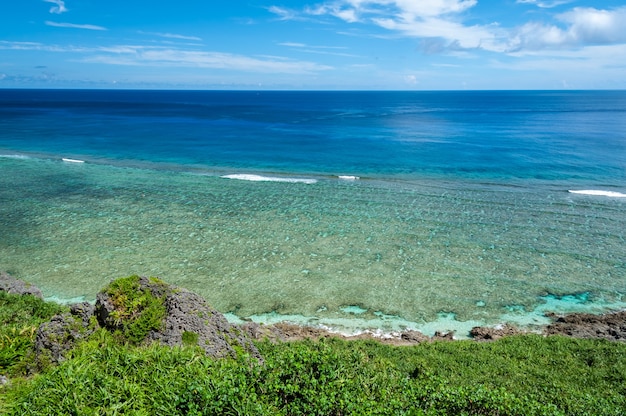 Stunning hillside with green vegetation rocks and pristine ocean full of coral reefs Yonaguni Island