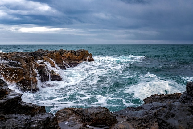 岩の多い海岸と海の上に美しい雲がある見事な海の風景