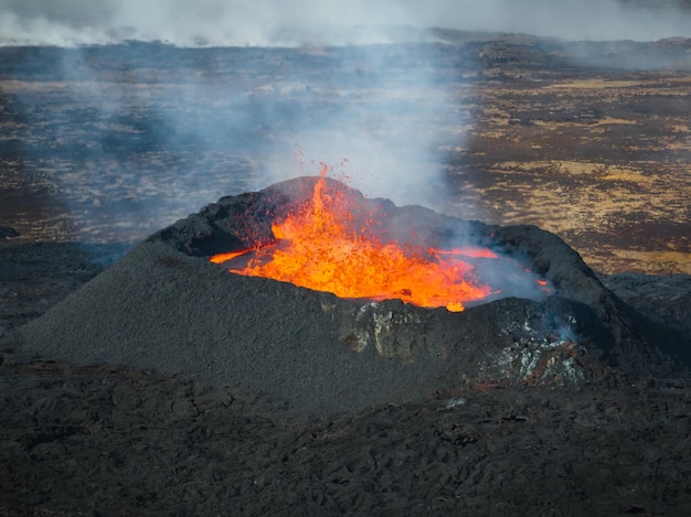 Stunning shot of dramatic moment of a volcano eruption summit crater with boiling magma aerial